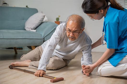 Nurse helping senior who fell on the ground