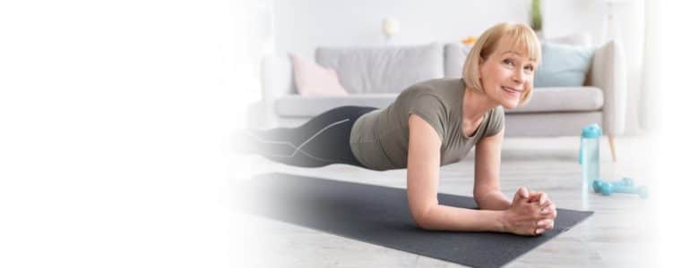 Senior woman on the ground in a plank position