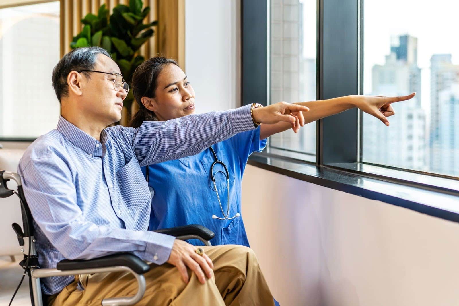Nurse and patient pointing outside a window