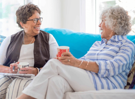 two women chatting on a couch