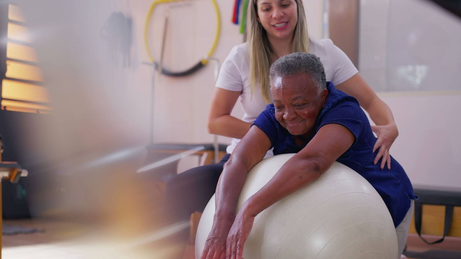 Personal care worker helping senior exercise